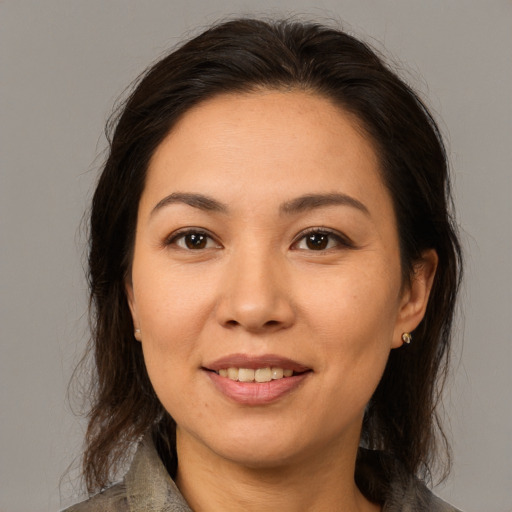 Joyful latino adult female with medium  brown hair and brown eyes