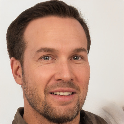 Joyful white adult male with short  brown hair and grey eyes