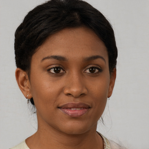 Joyful black young-adult female with short  brown hair and brown eyes