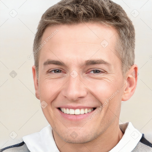 Joyful white young-adult male with short  brown hair and grey eyes