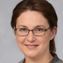 Joyful white adult female with medium  brown hair and grey eyes