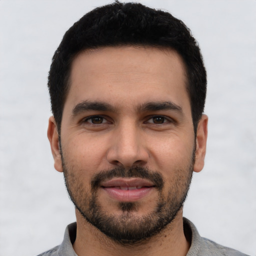 Joyful white young-adult male with short  black hair and brown eyes