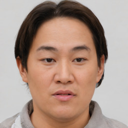 Joyful asian young-adult male with short  brown hair and brown eyes