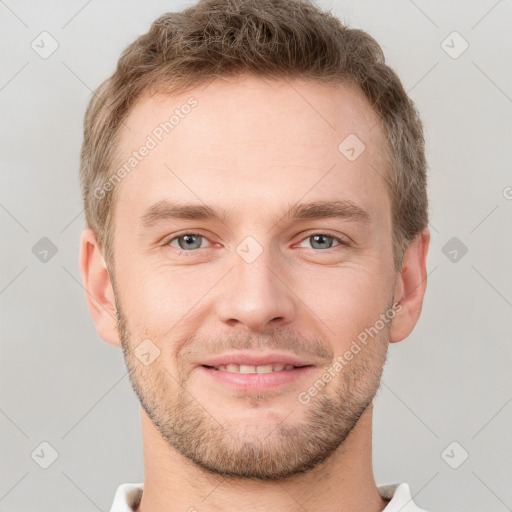 Joyful white young-adult male with short  brown hair and grey eyes