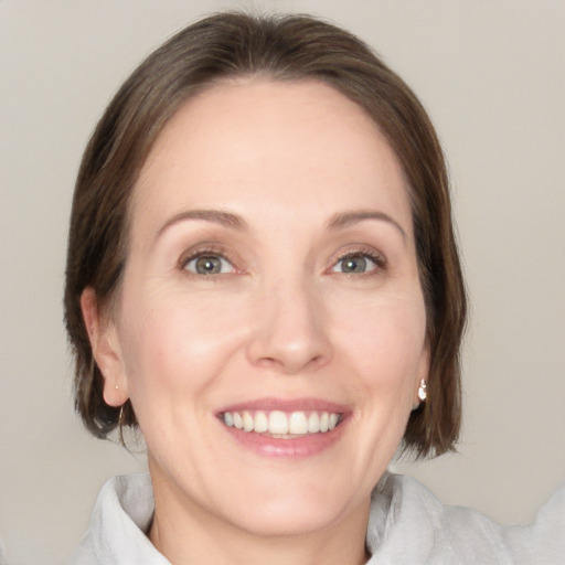 Joyful white adult female with medium  brown hair and green eyes