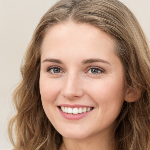 Joyful white young-adult female with long  brown hair and green eyes