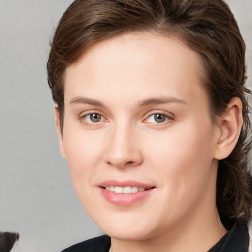 Joyful white young-adult female with medium  brown hair and grey eyes