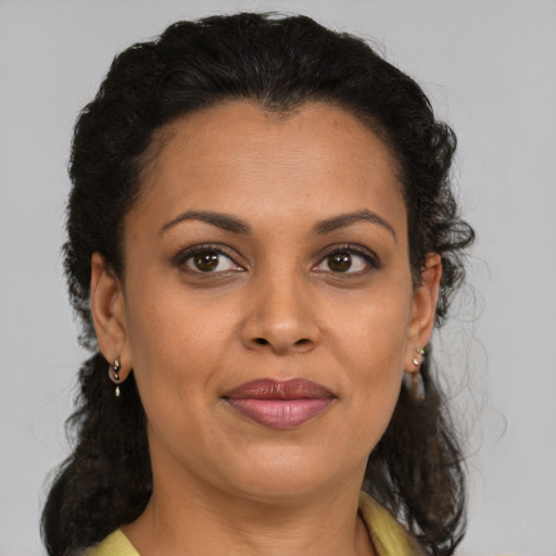 Joyful latino adult female with medium  brown hair and brown eyes