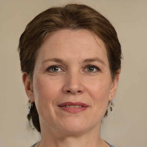 Joyful white adult female with medium  brown hair and green eyes