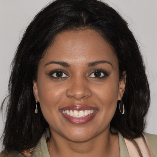 Joyful black young-adult female with long  brown hair and brown eyes