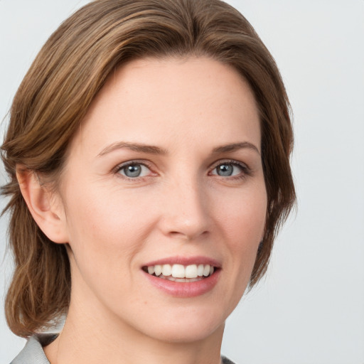 Joyful white young-adult female with medium  brown hair and green eyes