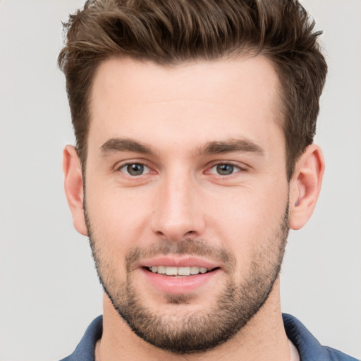 Joyful white young-adult male with short  brown hair and grey eyes