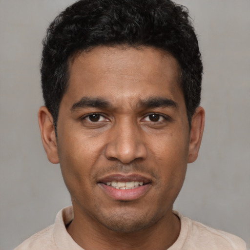 Joyful white young-adult male with short  black hair and brown eyes