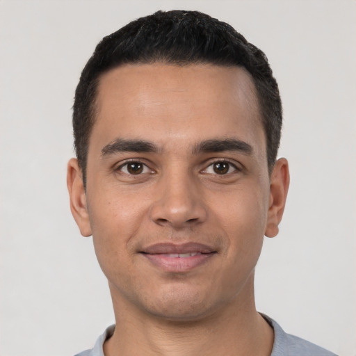 Joyful latino young-adult male with short  black hair and brown eyes