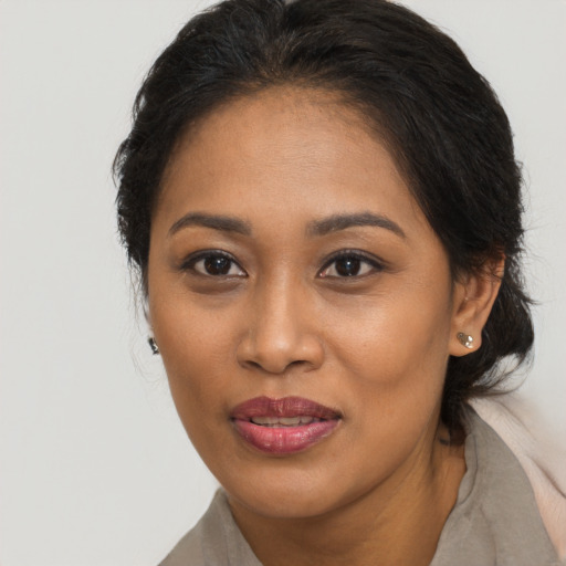 Joyful black young-adult female with medium  brown hair and brown eyes