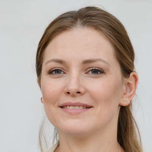 Joyful white young-adult female with long  brown hair and grey eyes