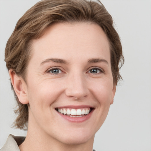 Joyful white young-adult female with medium  brown hair and grey eyes