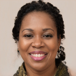 Joyful black adult female with long  brown hair and brown eyes