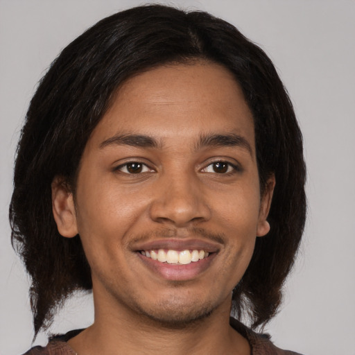 Joyful black young-adult male with medium  brown hair and brown eyes