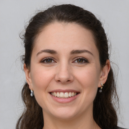 Joyful white young-adult female with long  brown hair and brown eyes