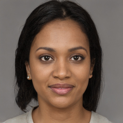 Joyful black young-adult female with medium  black hair and brown eyes