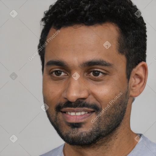 Joyful black young-adult male with short  black hair and brown eyes