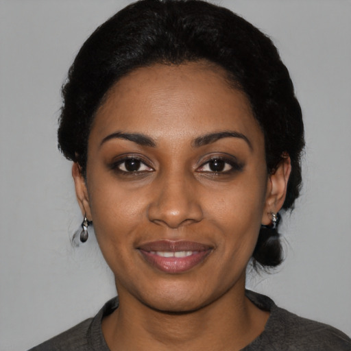 Joyful black young-adult female with short  black hair and brown eyes