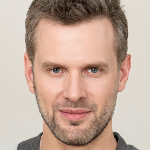 Joyful white adult male with short  brown hair and grey eyes