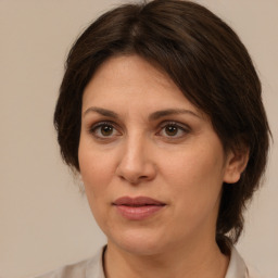 Joyful white adult female with medium  brown hair and brown eyes