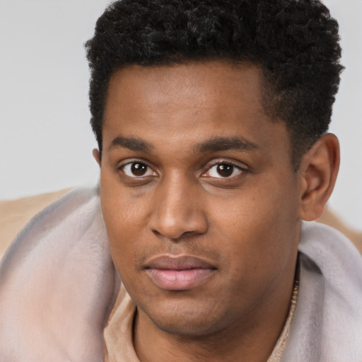 Joyful black young-adult male with short  brown hair and brown eyes