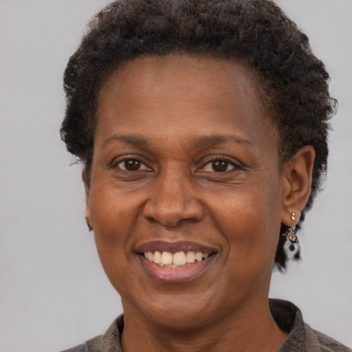Joyful black adult female with short  brown hair and brown eyes