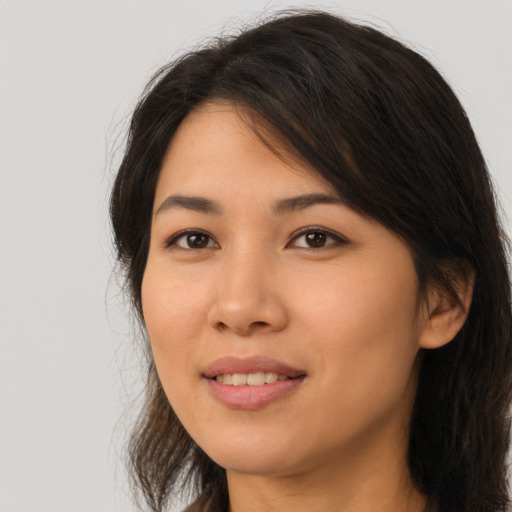 Joyful asian young-adult female with long  brown hair and brown eyes