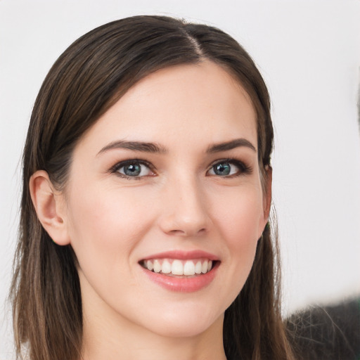 Joyful white young-adult female with long  brown hair and grey eyes