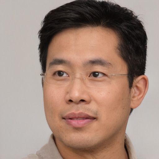 Joyful asian adult male with short  brown hair and brown eyes