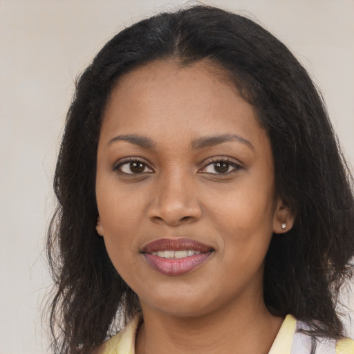 Joyful black young-adult female with long  brown hair and brown eyes
