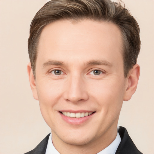 Joyful white young-adult male with short  brown hair and grey eyes