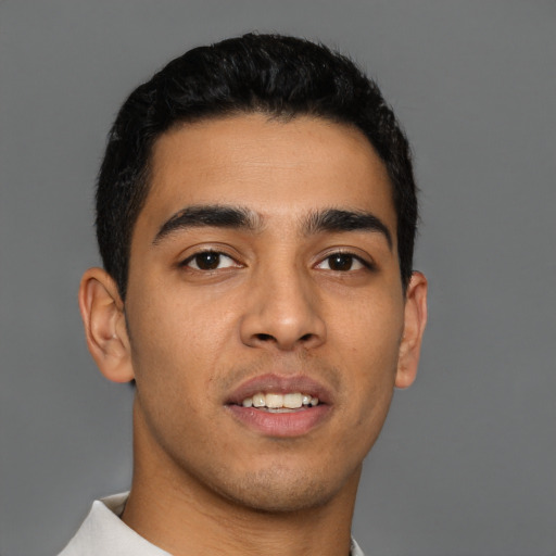 Joyful latino young-adult male with short  black hair and brown eyes