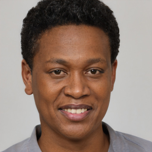 Joyful black adult male with short  black hair and brown eyes