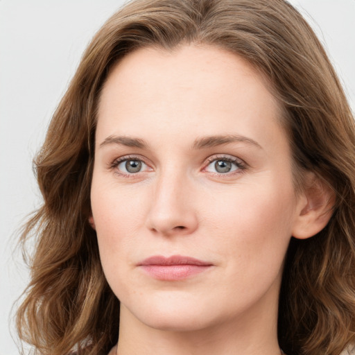 Joyful white young-adult female with long  brown hair and blue eyes