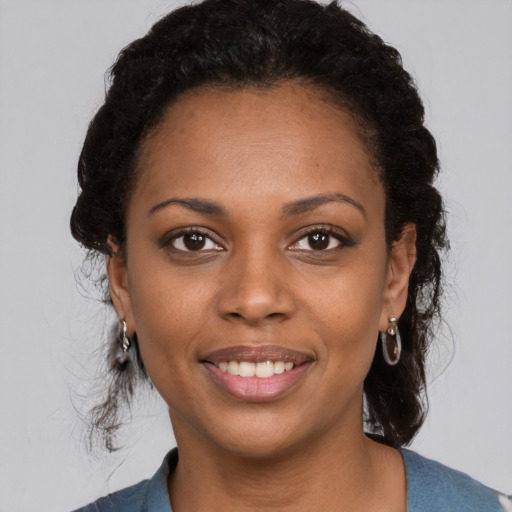 Joyful black young-adult female with medium  black hair and brown eyes