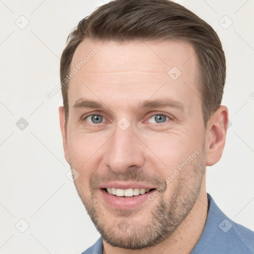 Joyful white young-adult male with short  brown hair and grey eyes