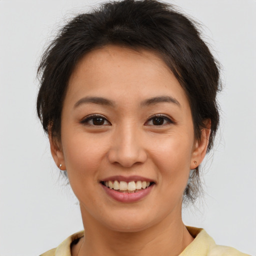 Joyful asian young-adult female with short  brown hair and brown eyes