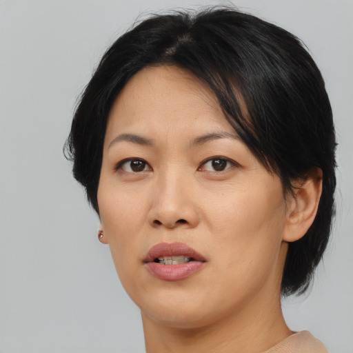 Joyful asian adult female with medium  brown hair and brown eyes