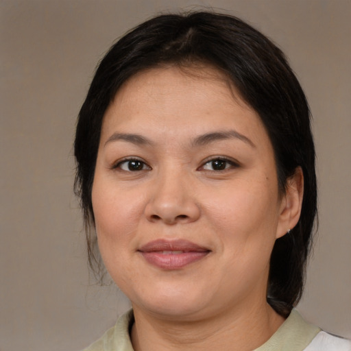 Joyful asian adult female with medium  brown hair and brown eyes