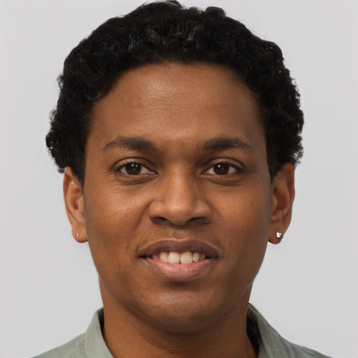 Joyful black young-adult male with short  brown hair and brown eyes