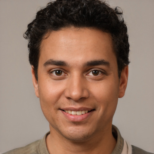 Joyful white young-adult male with short  black hair and brown eyes