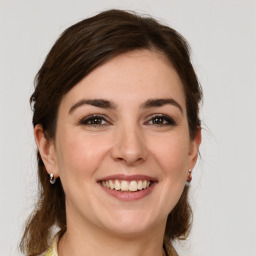 Joyful white young-adult female with medium  brown hair and grey eyes