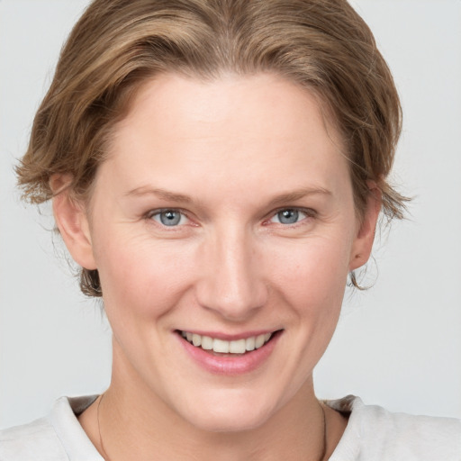 Joyful white young-adult female with medium  brown hair and grey eyes