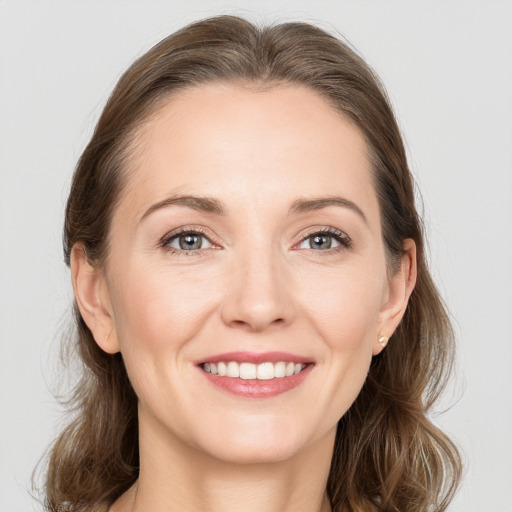 Joyful white young-adult female with medium  brown hair and grey eyes