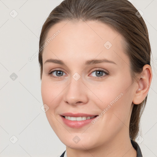 Joyful white young-adult female with medium  brown hair and grey eyes